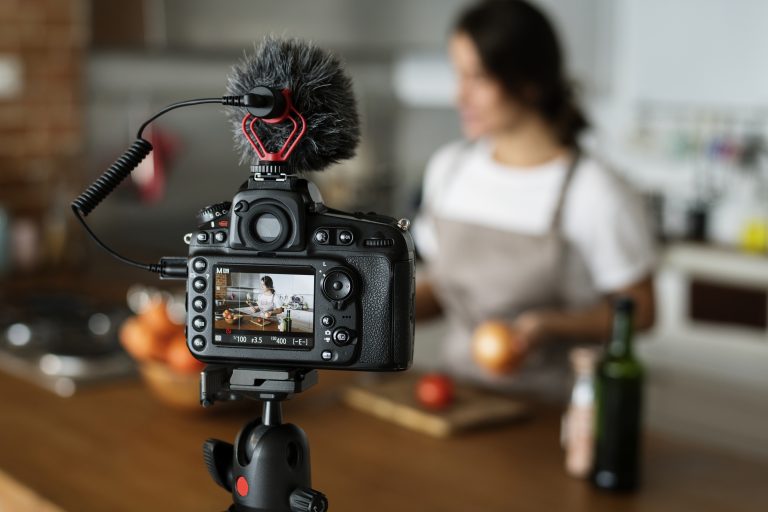 Female vlogger recording cooking related broadcast at home
